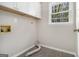 Laundry room with vinyl flooring, white cabinets, and window with wooded view at 20 King Pl, Stockbridge, GA 30281