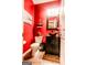 Stylish half bath with vibrant red walls, modern vanity, and decorative accents at 386 Hill Crest Cir, Hiram, GA 30141