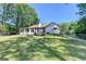 Rear view of home showing backyard, patio, sunroom, and mature trees, providing privacy at 4735 Rabbit Farm Rd, Loganville, GA 30052