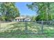 View of backyard with chain link fence and green grass surrounding a house with a sunroom at 4735 Rabbit Farm Rd, Loganville, GA 30052