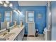 Bright bathroom featuring double sinks, white cabinets, tiled floors and an enclosed shower at 4735 Rabbit Farm Rd, Loganville, GA 30052