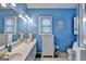 A blue bathroom with double sinks, large vanity and linen closet at 4735 Rabbit Farm Rd, Loganville, GA 30052