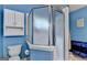 A blue bathroom showing the toilet and glass shower at 4735 Rabbit Farm Rd, Loganville, GA 30052