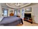 A primary bedroom with hardwood floors, large windows, and a tray ceiling at 4735 Rabbit Farm Rd, Loganville, GA 30052