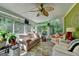 Bright sunroom featuring stone floors, large windows, a leaf ceiling fan, and comfortable seating at 4735 Rabbit Farm Rd, Loganville, GA 30052