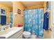 Bathroom with floral shower curtain, white vanity, and neutral walls at 335 Jeff Davis Pl, Fayetteville, GA 30214