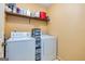 Functional laundry room featuring a washer, dryer, and storage shelves at 335 Jeff Davis Pl, Fayetteville, GA 30214