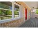 Close-up of the front porch with brick facade and red door, creating a cozy entrance at 4014 Golfview Dr, Villa Rica, GA 30180