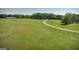Expansive property featuring a farmhouse, barn, open pasture land, and an unpaved drive at 201 Little New York Rd, Carrollton, GA 30116