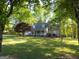 Idyllic setting with a welcoming home, enveloped by mature trees and a verdant lawn at 201 Little New York Rd, Carrollton, GA 30116