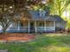 This lovely home offers a spacious front porch with charming landscaping and mature trees at 201 Little New York Rd, Carrollton, GA 30116