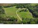 Aerial perspective showcases the property's generous acreage, verdant pastures, and tranquil wooded areas at 201 Little New York Rd, Carrollton, GA 30116