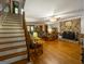 Spacious living room featuring hardwood floors, staircase, stone fireplace, and comfortable furniture at 201 Little New York Rd, Carrollton, GA 30116