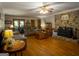 Traditional living room with wood floors, stone fireplace, ceiling fan and comfortable seating at 201 Little New York Rd, Carrollton, GA 30116