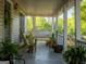 Inviting covered porch showcasing a swing, outdoor seating, charming plants and wood flooring at 201 Little New York Rd, Carrollton, GA 30116