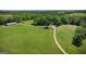Expansive property featuring a home, outbuildings, and fenced pasture with a long gravel driveway at 201 Little New York Rd, Carrollton, GA 30116