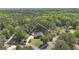 Stunning aerial view of a red brick home with a lush green lawn surrounded by mature trees, showcasing privacy and curb appeal at 65 Jacksons Vly, Sharpsburg, GA 30277
