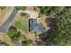 Aerial of the home in a wooded neighborhood with a long circular drive and mature landscaping at 65 Jacksons Vly, Sharpsburg, GA 30277