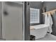 Stylish bathroom featuring a white soaking tub, shower, and decorative shelving with hanging towels at 65 Jacksons Vly, Sharpsburg, GA 30277