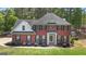 A charming two-story red brick home with landscaped yard and a lush green lawn at 65 Jacksons Vly, Sharpsburg, GA 30277