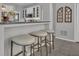 Kitchen with bar seating and white cabinets with glass fronts, granite countertops, and wooden wall decor at 65 Jacksons Vly, Sharpsburg, GA 30277