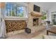 Inviting living room featuring a brick fireplace, wood storage, and a large window with a scenic view at 65 Jacksons Vly, Sharpsburg, GA 30277
