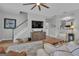 Cozy living room with hardwood flooring, stairs, tv, storage unit, and view to kitchen at 65 Jacksons Vly, Sharpsburg, GA 30277