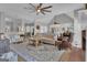 Open concept living room with hardwood floors, rug, ceiling fan, and view to dining area at 65 Jacksons Vly, Sharpsburg, GA 30277