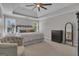Spacious main bedroom with tray ceilings, ceiling fan, carpet, and windows letting in natural light at 65 Jacksons Vly, Sharpsburg, GA 30277