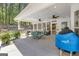 Outdoor patio with covered area, ceiling fans, a dining table, grill, and views of the private yard at 65 Jacksons Vly, Sharpsburg, GA 30277