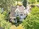 Aerial view of a gray two-story home with a backyard deck and a two-car garage surrounded by lush trees at 110 Cadmium Ct, Peachtree City, GA 30269