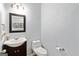 A well-lit half bathroom features a modern vanity, a framed mirror and a standard toilet at 110 Cadmium Ct, Peachtree City, GA 30269