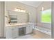 Primary bathroom features a soaking tub, dual vanity sinks, tile flooring, and large mirror at 110 Cadmium Ct, Peachtree City, GA 30269