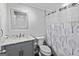 Neutral bathroom featuring a vanity with marble countertop, decorative mirror and tiled shower with a patterned curtain at 110 Cadmium Ct, Peachtree City, GA 30269