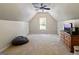 A large bonus room with neutral carpet, a ceiling fan, and natural light from the window at 110 Cadmium Ct, Peachtree City, GA 30269