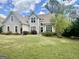 Charming two-story home with a well-manicured lawn, lush landscaping, and a stately stucco facade at 110 Cadmium Ct, Peachtree City, GA 30269