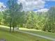 Scenic view of a lush green golf course with mature trees and a cart path at 110 Cadmium Ct, Peachtree City, GA 30269