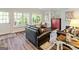 Cozy living room featuring hardwood floors, a large bay window, and leather furniture at 110 Cadmium Ct, Peachtree City, GA 30269