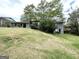 A beautiful front exterior view of the home with lush green lawn, mature trees, and covered porch at 668 Fielding Sw Ln, Atlanta, GA 30311