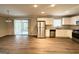 Modern kitchen with stainless steel appliances, white cabinets, hardwood floors, and sliding doors to the outdoor living area at 668 Fielding Sw Ln, Atlanta, GA 30311