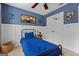 Bedroom with blue walls, white wainscoting, a ceiling fan and two windows at 220 Calli Ct, Mcdonough, GA 30252
