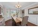 Bright dining room features hardwood floors, a wooden table with upholstered chairs and plenty of natural light at 220 Calli Ct, Mcdonough, GA 30252