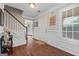 Bright foyer with hardwood floors, a staircase, and a view into the dining area at 220 Calli Ct, Mcdonough, GA 30252