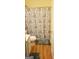 This bathroom features a toilet, light colored vanity, shower with patterned curtain, and hardwood flooring at 472 Harvick Cir, Stockbridge, GA 30281