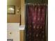 Bathroom features a shower with burgundy floral curtain next to a soaking tub with white tile surround at 472 Harvick Cir, Stockbridge, GA 30281