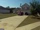 Two-story home boasts a well-manicured front lawn, a long driveway and attached two-car garage at 472 Harvick Cir, Stockbridge, GA 30281