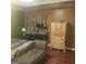 A main bedroom featuring a chaise lounge, wood floors, and natural wood furniture at 472 Harvick Cir, Stockbridge, GA 30281
