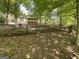 View of the wooded backyard with mature trees and a black chain link fence at 5363 Forest Dr, Loganville, GA 30052