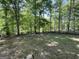 Serene backyard with lush green grass, mature trees and a rustic wooden fence at 5363 Forest Dr, Loganville, GA 30052