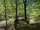 View of a wooden viewing platform near the wooded backyard with mature trees and a lake at 5363 Forest Dr, Loganville, GA 30052